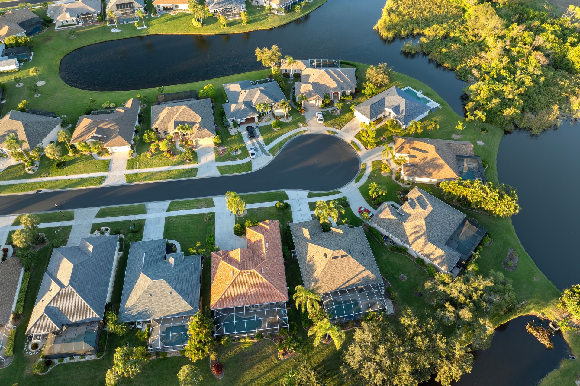 View from above of residential houses in living area in North Port, FL at evening. Illuminated American dream homes as example of real estate development in US suburbs